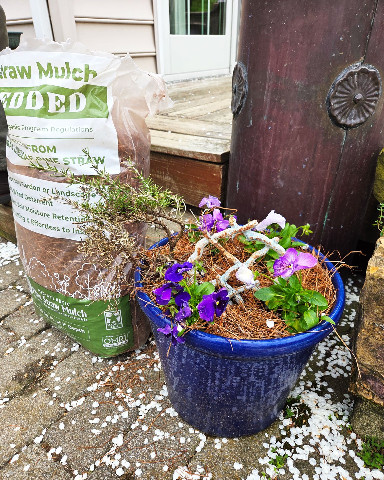 Shredded Pine Straw Organic Mulch Bag next to Pot with Pansies
